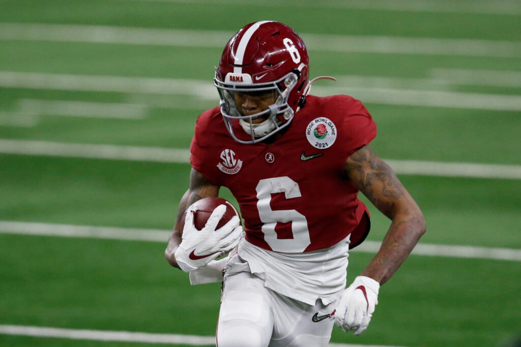 DeVonta Smith Alabama Football sprinting on green turf in crimson jersey dynamic sports action Wallpaper