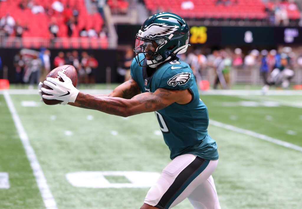 DeVonta Smith Philadelphia Eagles catching football in game vibrant green uniform stadium action Wallpaper