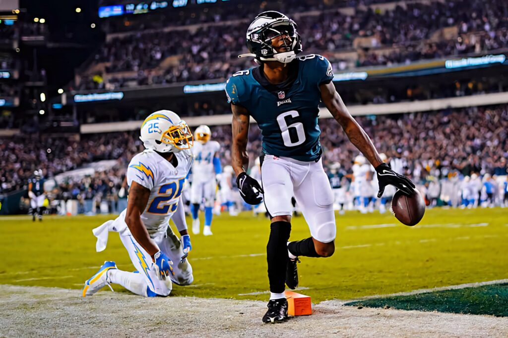 DeVonta Smith scores touchdown with determination in vibrant stadium action football wallpaper background