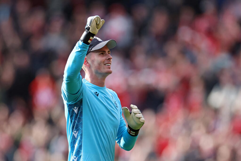 Dean Henderson celebrating victory in blue goalkeeper kit with raised fist in vibrant stadium Wallpaper