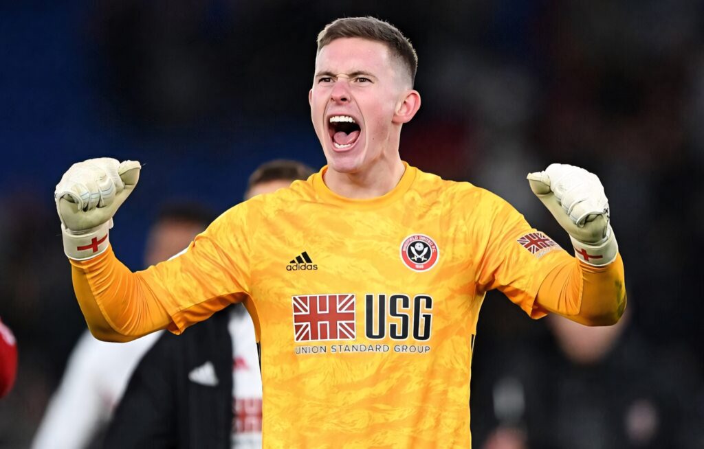 Dean Henderson shouting with clenched fists in bright yellow Sheffield United goalkeeper kit on field Wallpaper