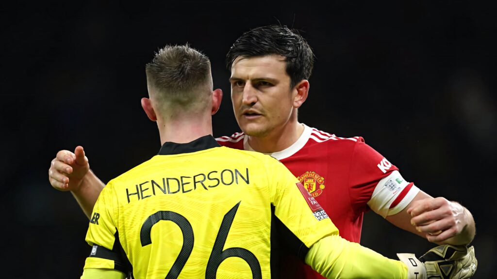 Dean Henderson in bright yellow goalkeeper kit hugging Harry Maguire in Manchester United red jersey football wallpaper