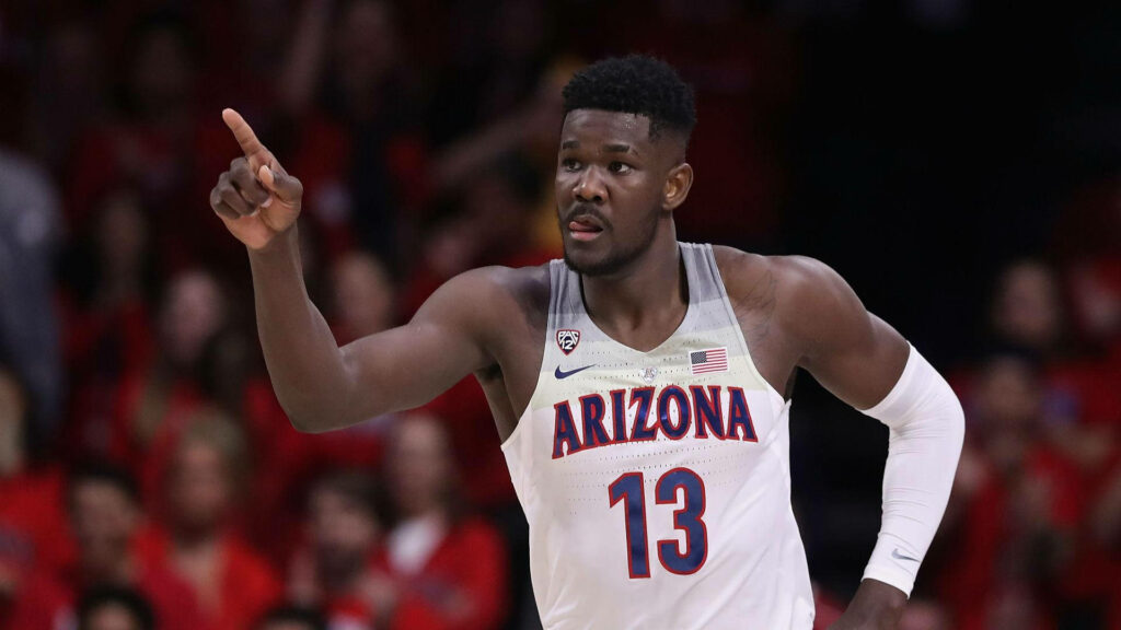 Deandre Ayton intense Arizona Wildcats basketball action with vibrant crowd and bold team colors Wallpaper