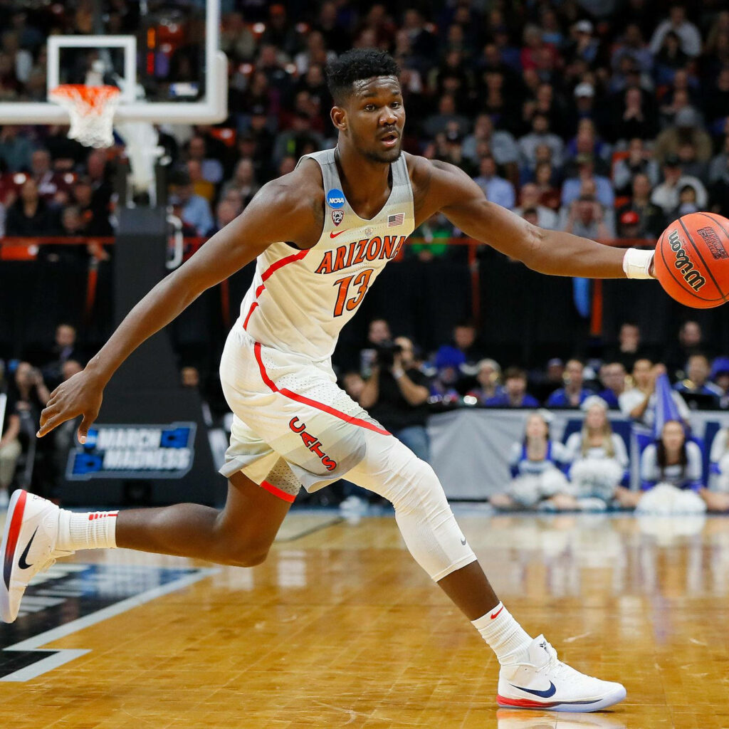 Deandre Ayton dribbling for Arizona Wildcats NCAA basketball game in white and red uniform Wallpaper