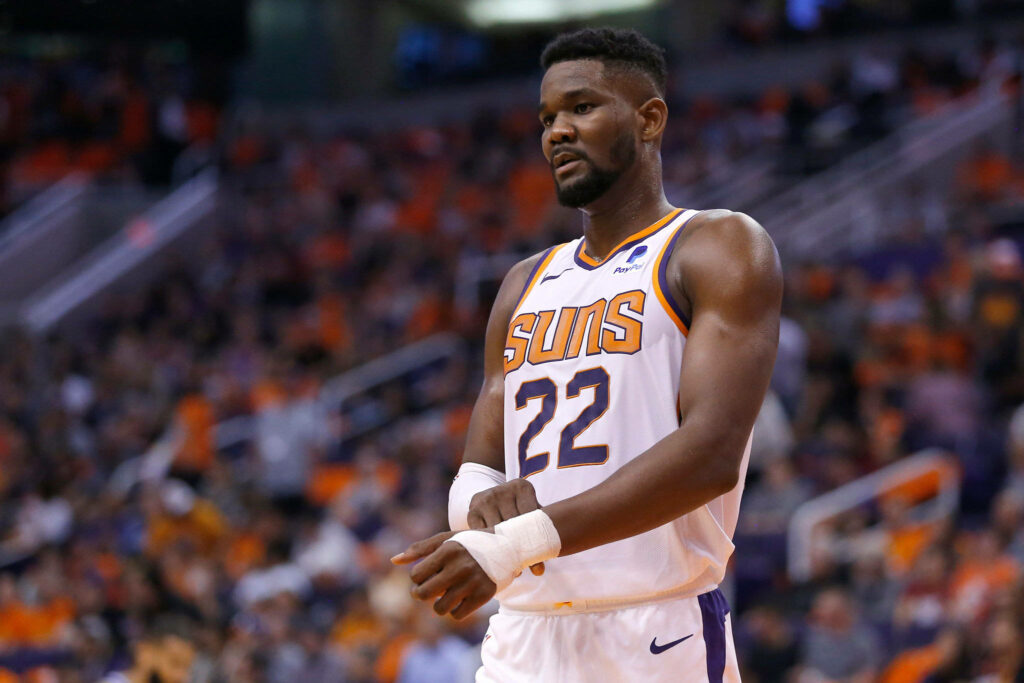 Deandre Ayton Phoenix Suns basketball player in white purple jersey on crowded NBA arena court Wallpaper