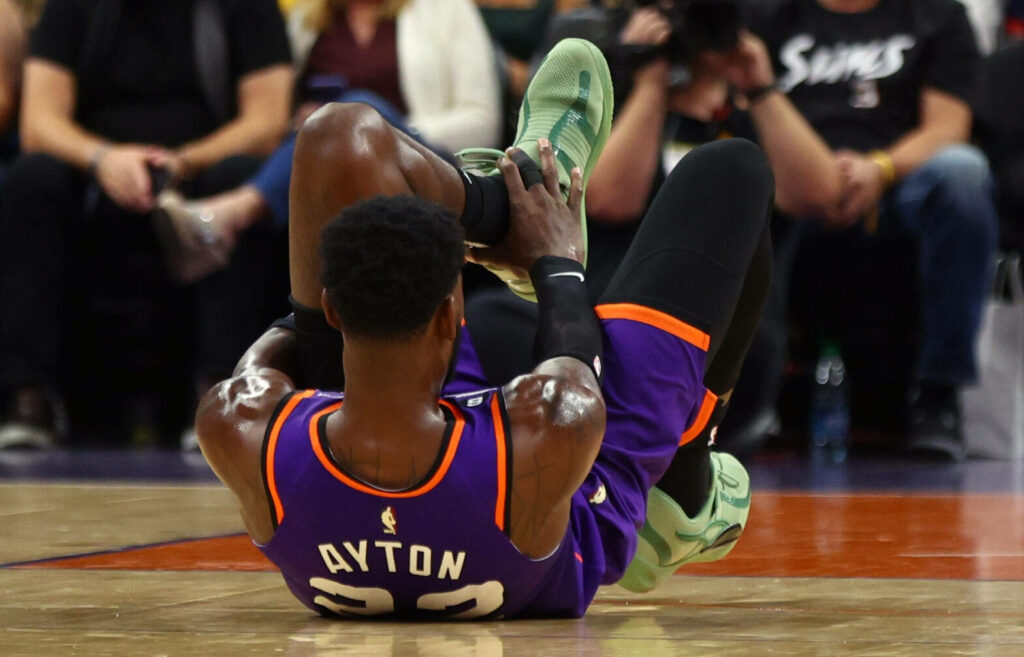 Deandre Ayton in Phoenix Suns jersey number 22 playing intense NBA basketball purple orange colors Wallpaper