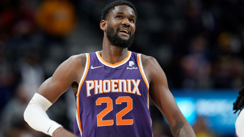 Deandre Ayton in Phoenix Suns jersey mid-game dynamic lighting NBA action vibrant uniform Wallpaper