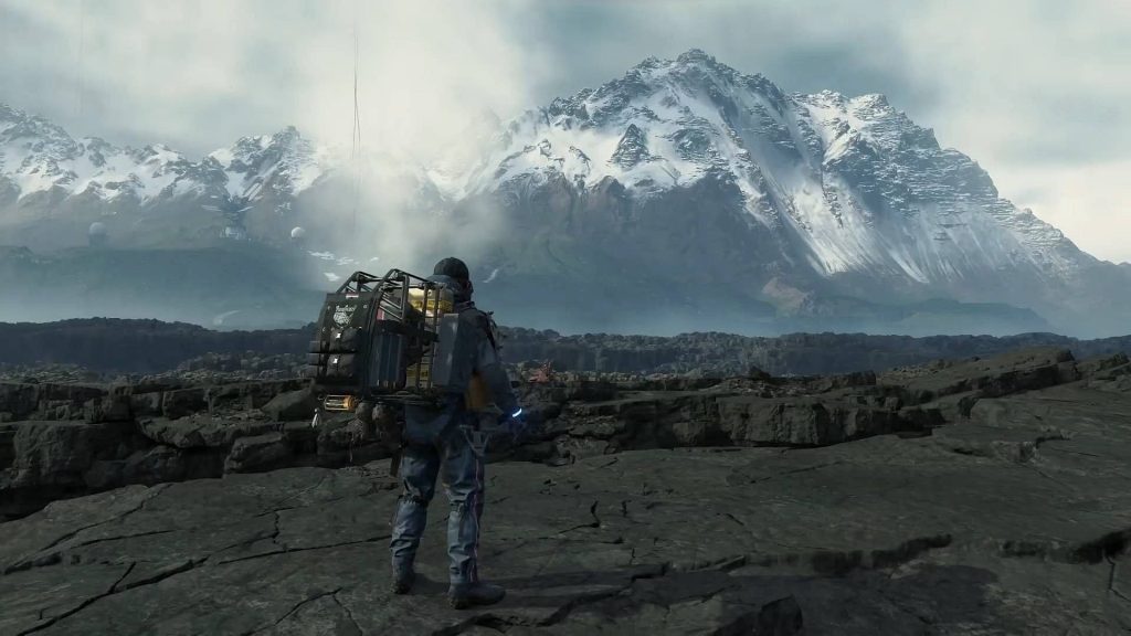 Sam Porter Bridges views vast rugged landscape under snow-capped mountains Death Stranding wallpaper