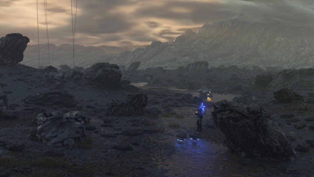 Sam Porter Bridges in rocky Death Stranding twilight terrain with glowing Odradek and truck background Wallpaper