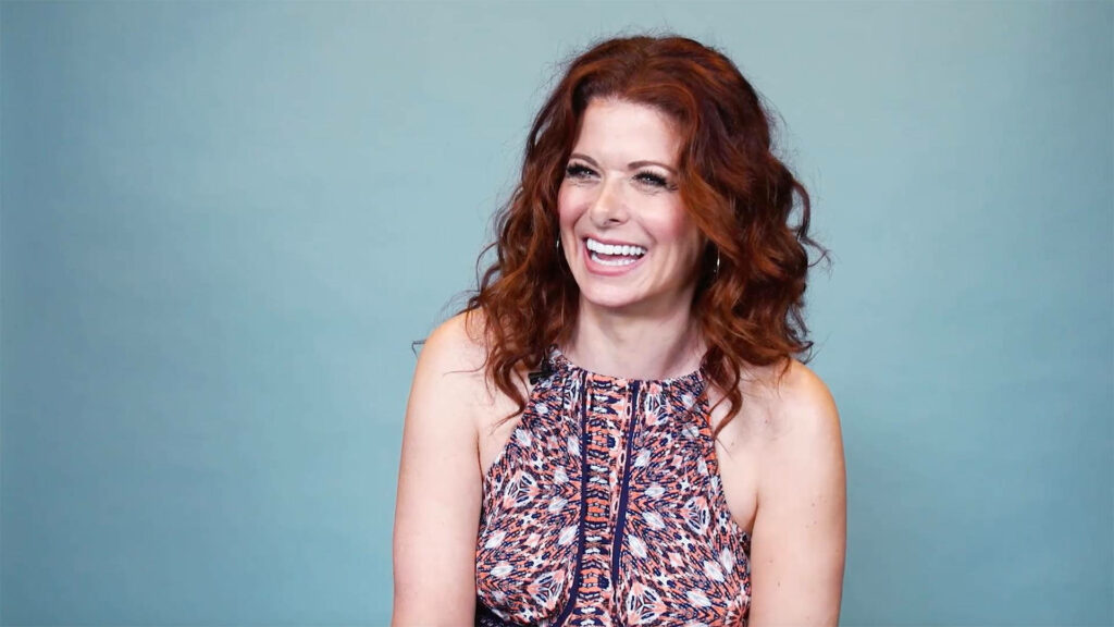 Debra Messing smiling in patterned dress with wavy auburn hair during Today interview background Wallpaper