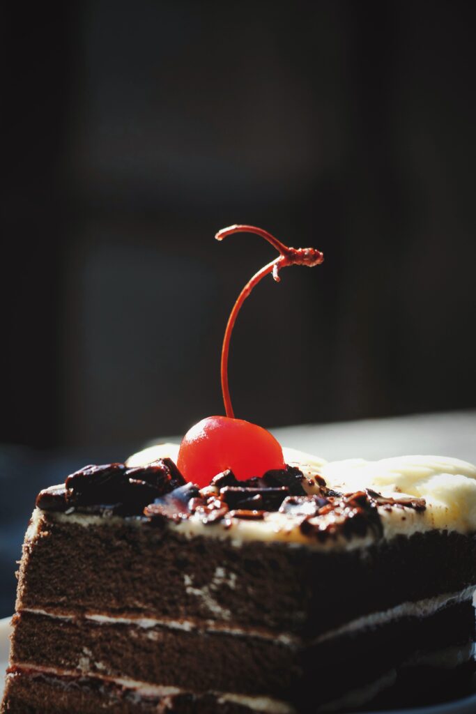 Decadent Chocolate Cake Slice with Cream & Cherry Wallpaper