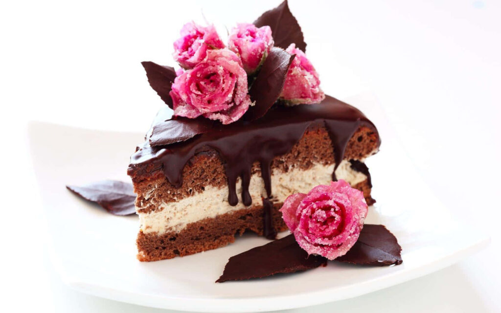 Decadent chocolate cake wallpaper with glossy ganache and pink rose floral accents background