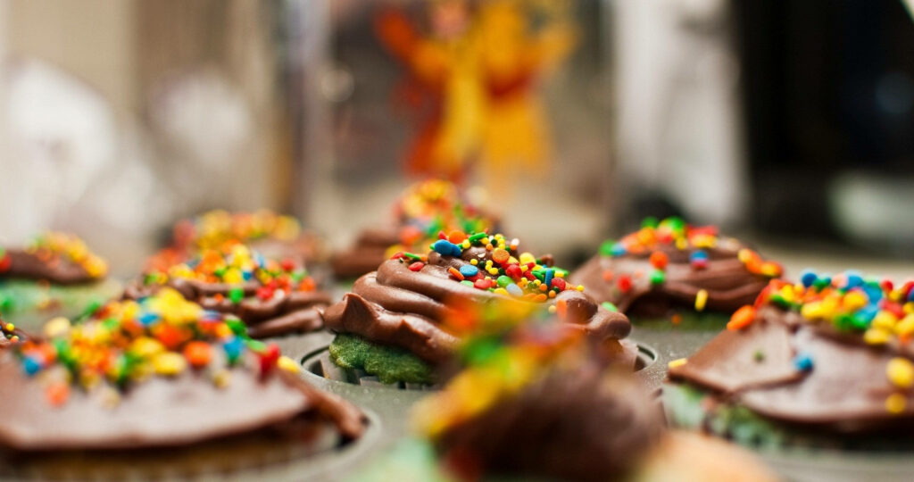 Chocolate cupcakes adorned with sprinkles, a sweet and vibrant treat Wallpaper