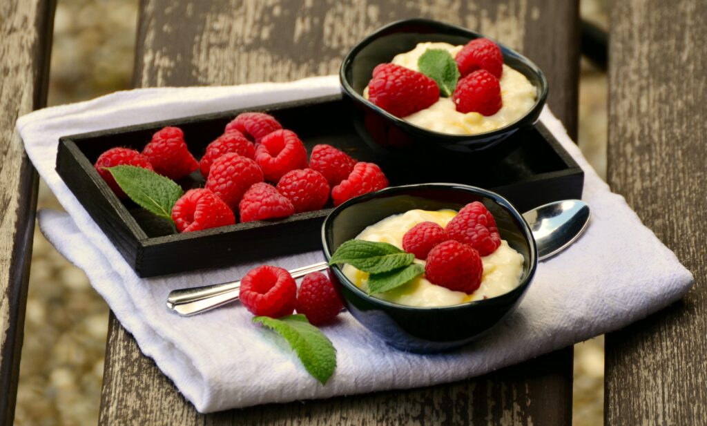 Delicious Raspberry Dessert in Rustic Black Bowls - Wallpaper Background