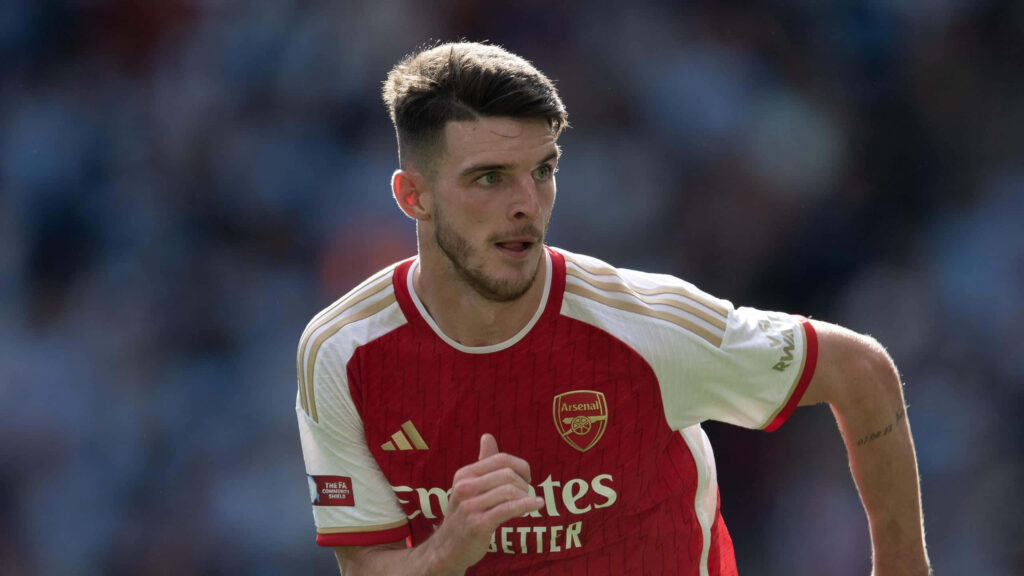 Declan Rice in red and white Arsenal kit focused in action soccer field dynamic vibrant wallpaper