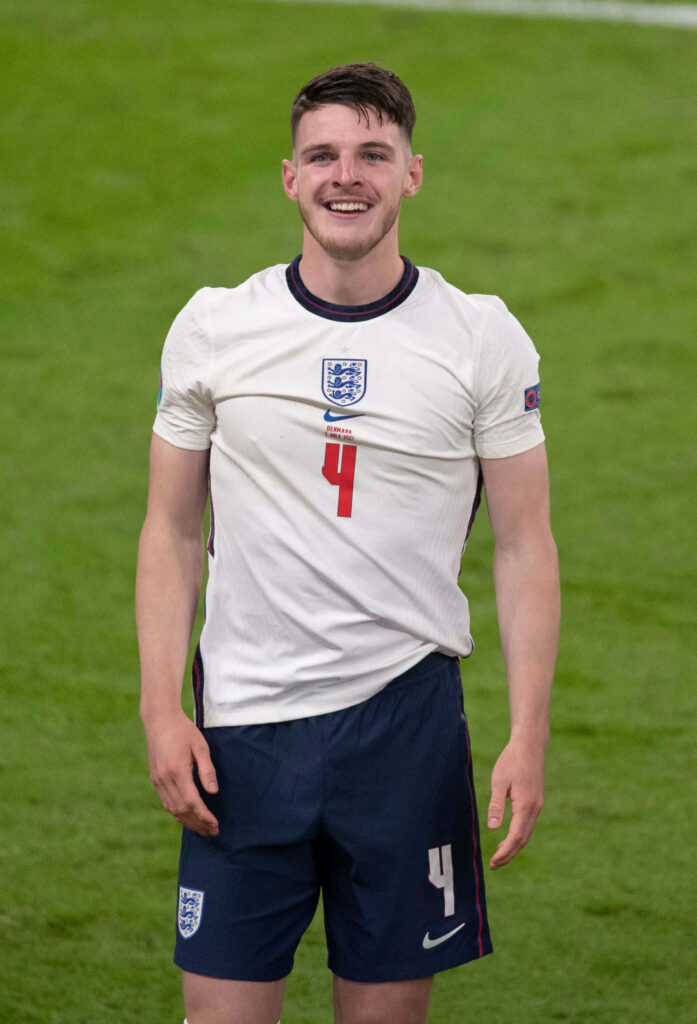 Declan Rice in England white jersey number 4 and navy shorts on football pitch wallpaper background