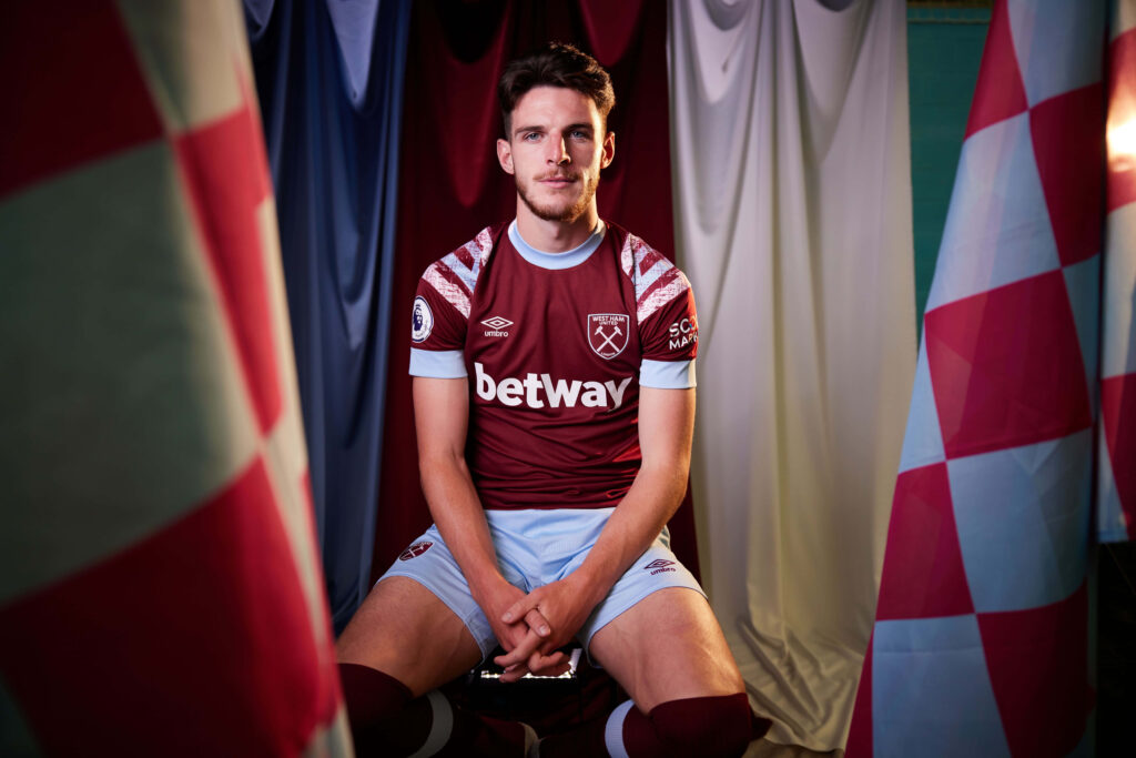 Declan Rice in classic West Ham United claret and blue kit with team colors background wallpaper
