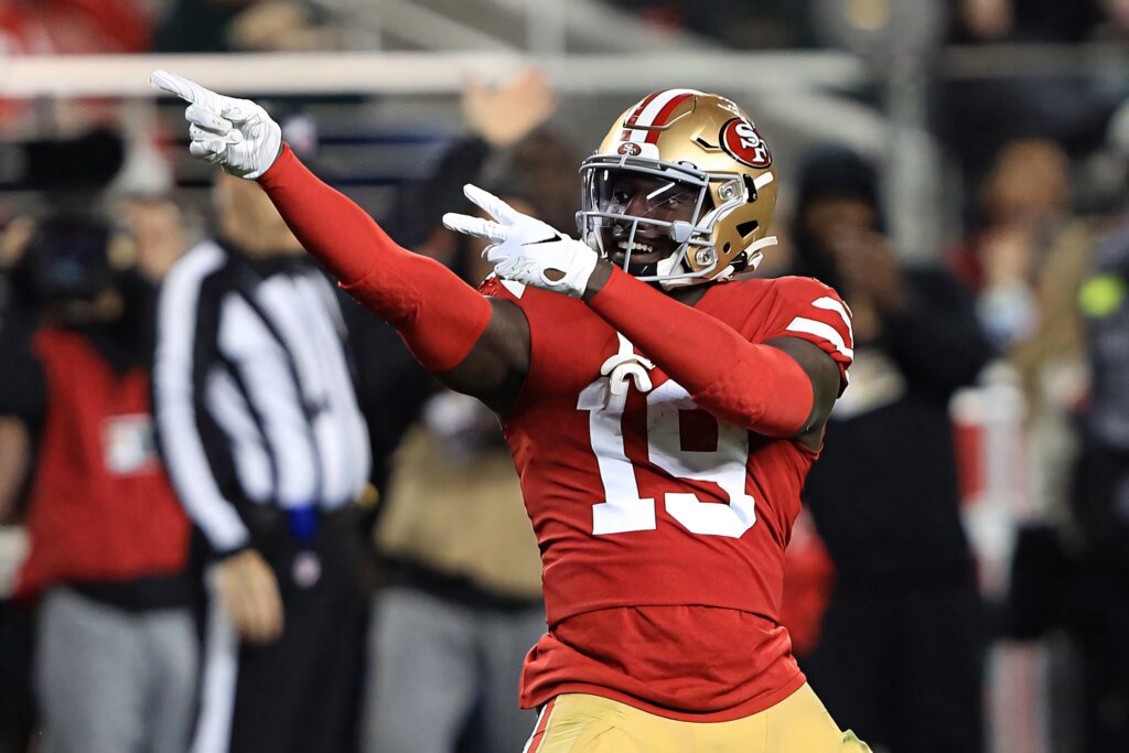 Deebo Samuel Sr celebrating in San Francisco 49ers red and gold jersey on football field Wallpaper