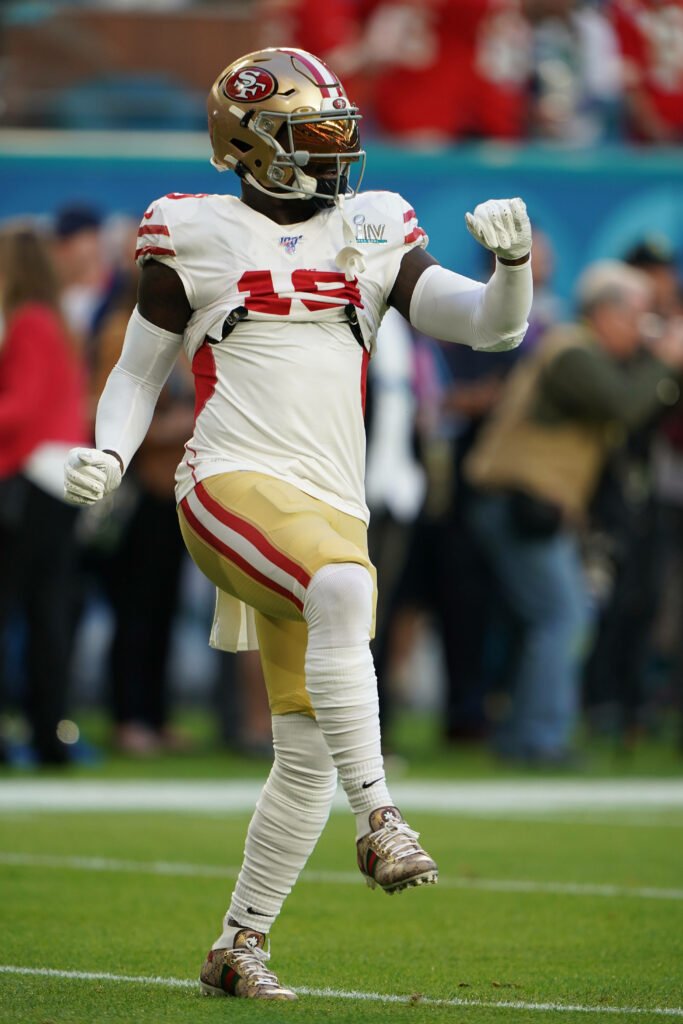 Deebo Samuel Sr. balancing on one foot in San Francisco 49ers uniform game action wallpaper
