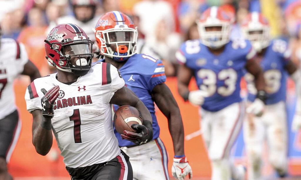 Deebo Samuel Sr running fast in South Carolina football uniform during intense game action Wallpaper