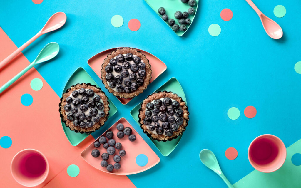 Scrumptious Blueberry Cupcakes Temptingly Arranged on a Vibrant Tabletop: A Visual Feast Wallpaper
