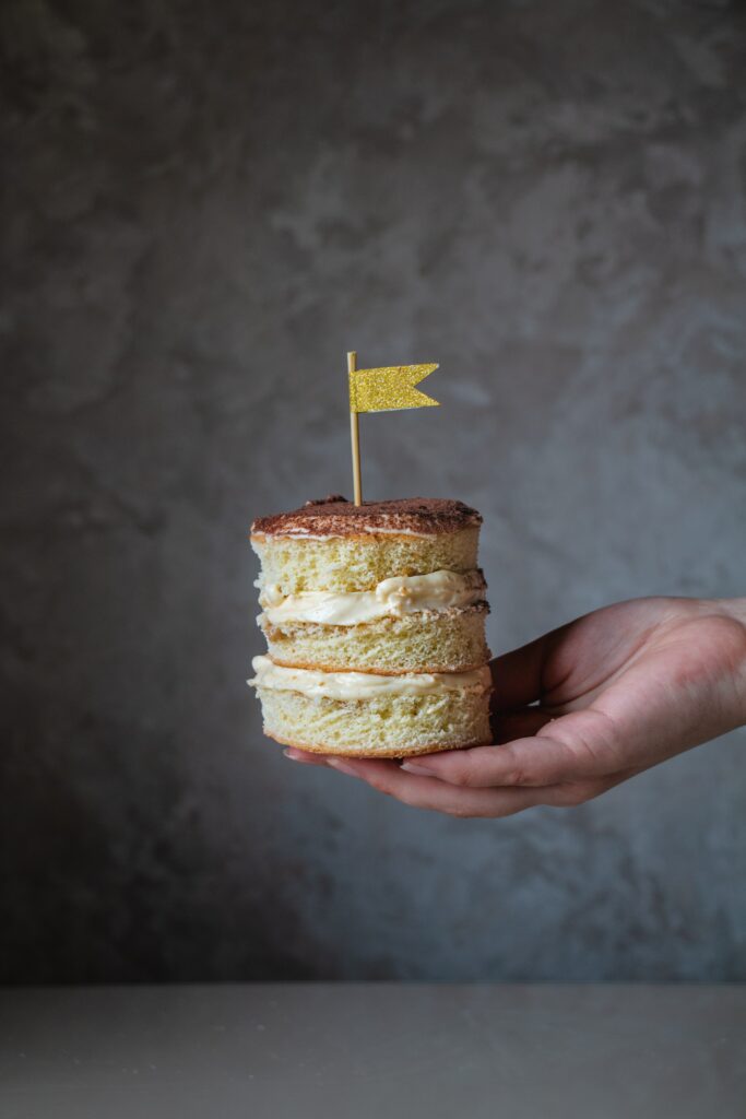 Delicious Layered Cake Dessert with Flag on Soft Gray Wallpaper