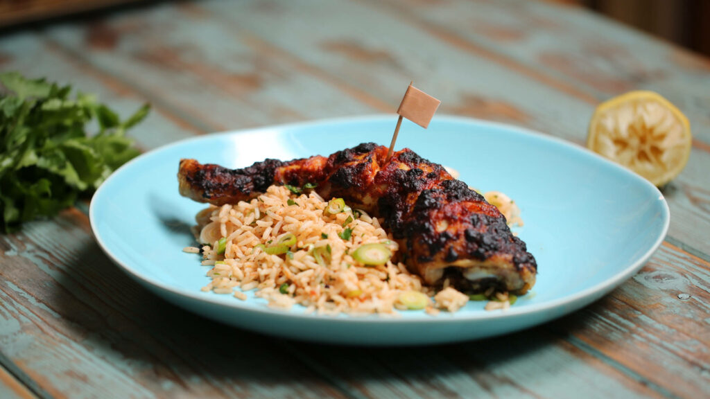 Delicious Peri Peri Chicken Leg Wallpaper with Flavorful Rice & Greens