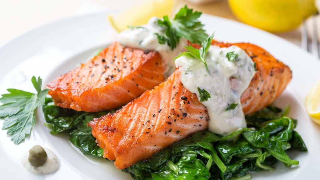 Delicious Salmon Fillets Wallpaper: Creamy Sauce & Fresh Spinach