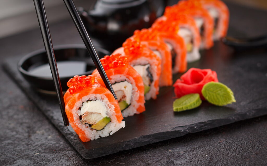 4K gourmet Philadelphia sushi roll with salmon and caviar on slate tray with soy sauce Wallpaper