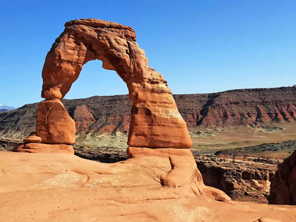 Delicate Arch Utah landscape with red rock formations and clear blue sky natural desert scene Wallpaper