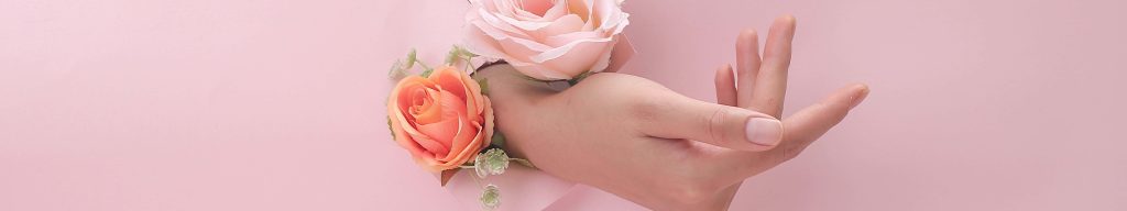 Hand through torn pink paper with peach and pink artificial roses minimalist widescreen wallpaper