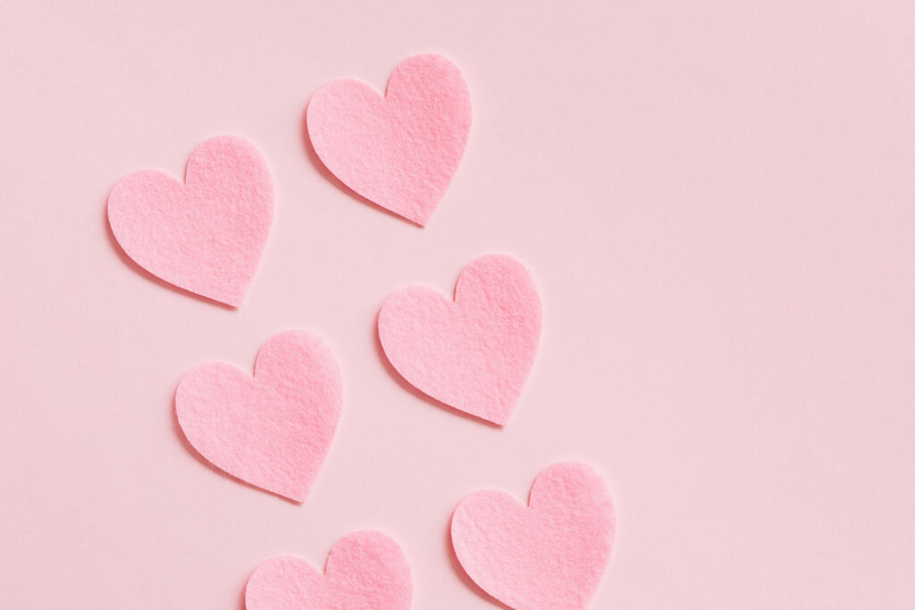 Delicate Pink Heart Cutouts Wallpaper for a Romantic Aesthetic