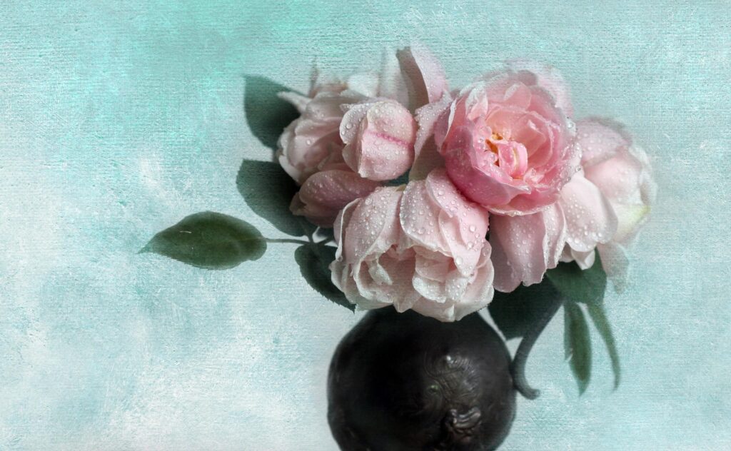 Delicate Pink Roses in Vase on Light Blue Textured Background Wallpaper