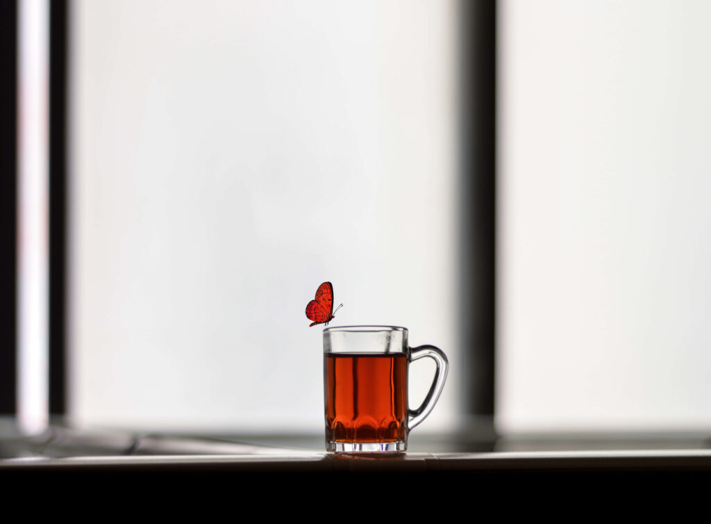 Serene Red Butterfly on Tea Glass: Minimalist Wallpaper Background