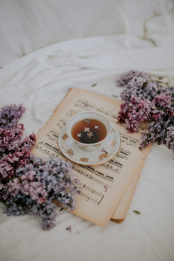 Delicate Tea Cup on Musical Notes with Lilac Flowers Wallpaper