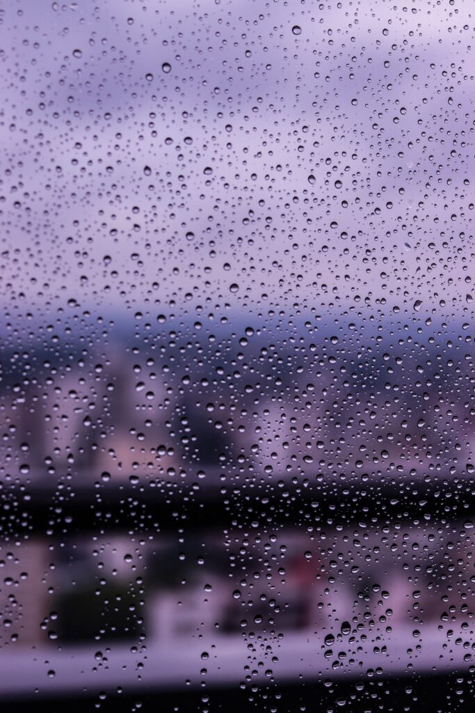 Delicate Water Droplets on Glass: Purple Blurred Wallpaper Background