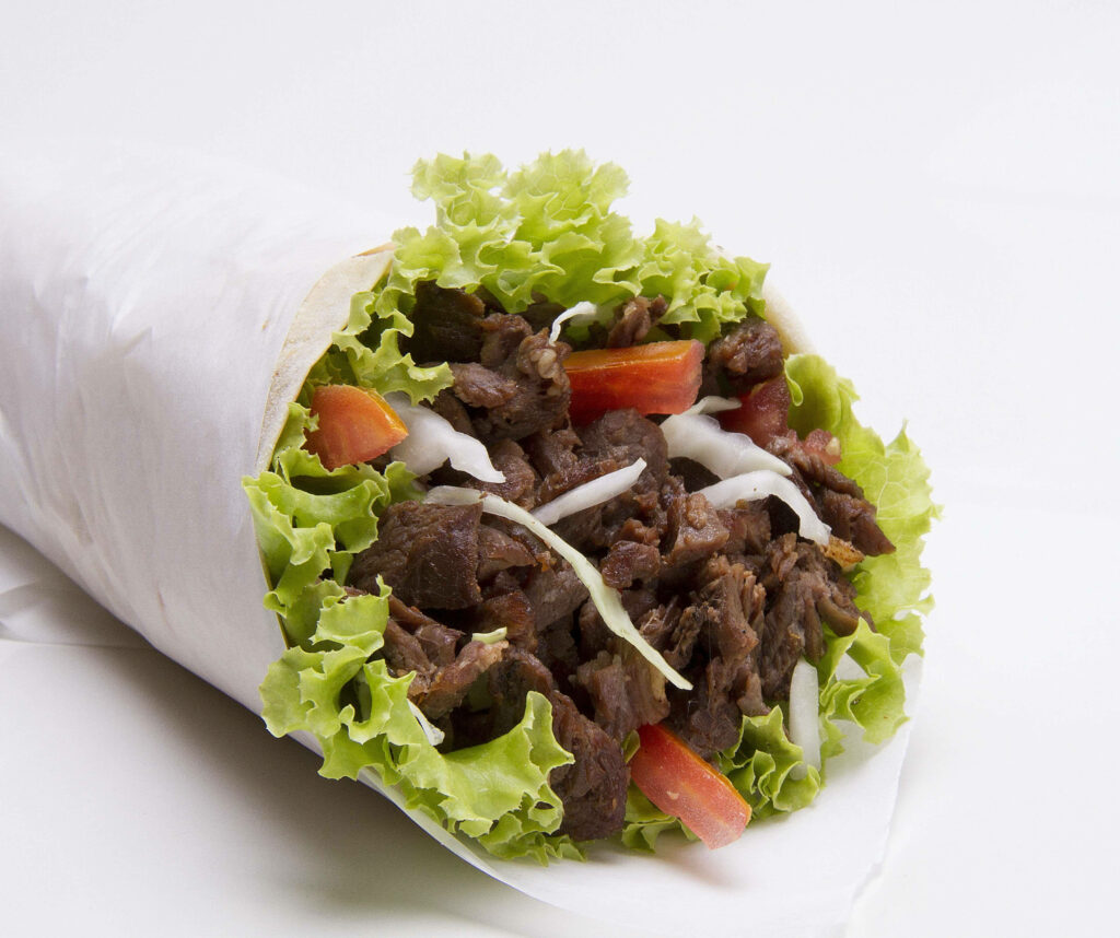 Close-up of beef burrito with juicy beef lettuce tomatoes cheese soft tortilla on white background Wallpaper