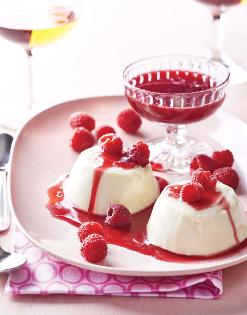 Blancmange desserts with vibrant raspberry sauce and fresh raspberries food wallpaper background