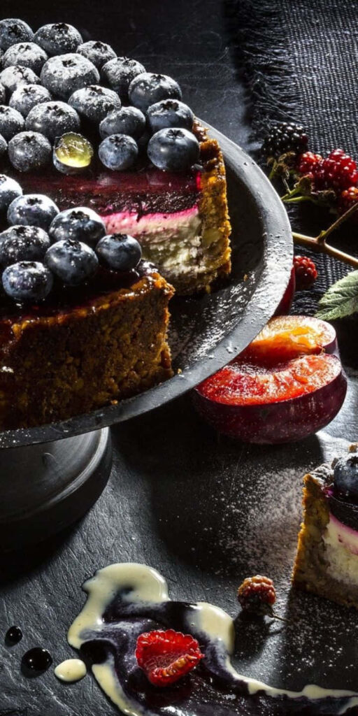 Blueberry cheesecake with fresh berries glossy glaze vibrant dessert wallpaper background