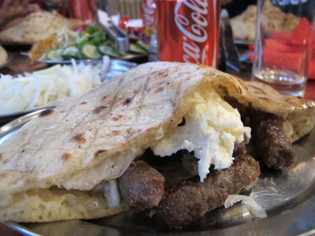Delicious Cevapi Sausages with Flatbread & Coca-Cola Wallpaper Background