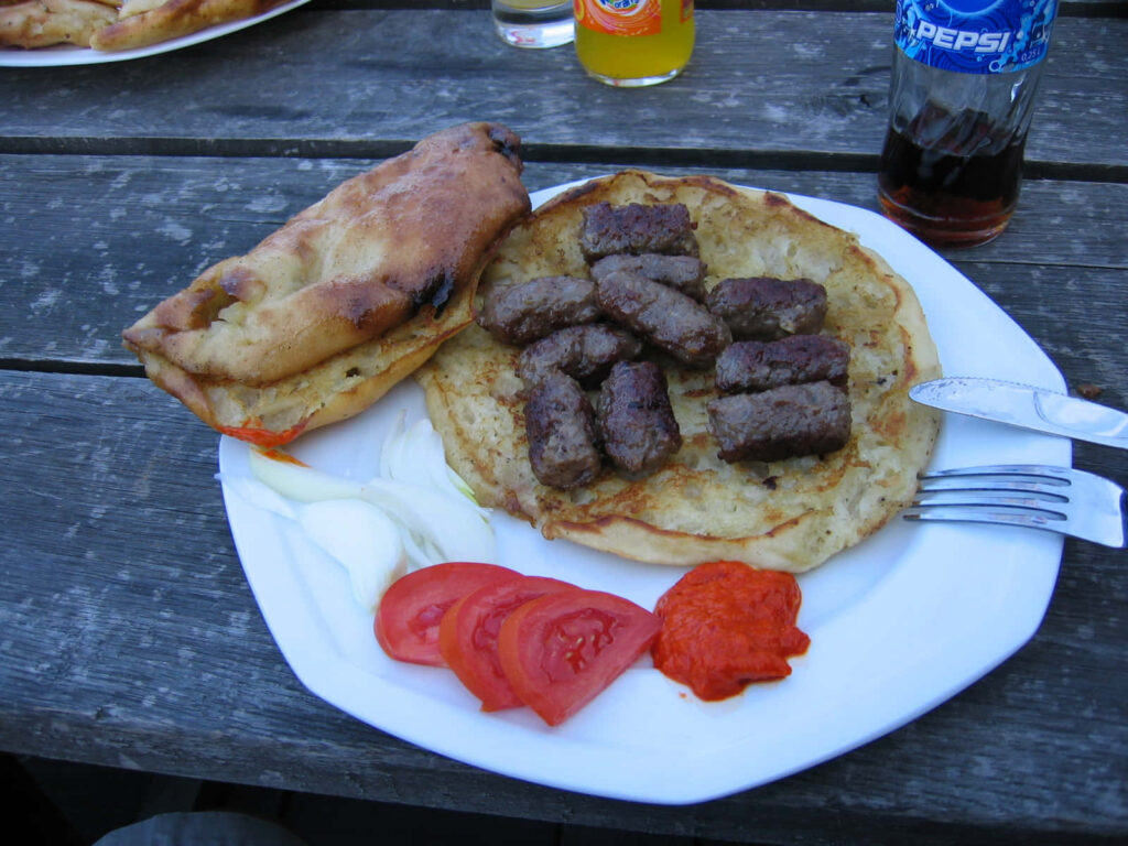 Delicious Ćevapi on Flatbread with Fresh Toppings - Rustic Wallpaper