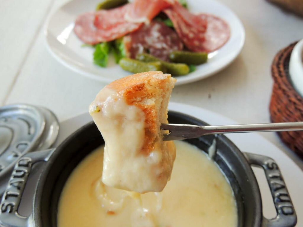 Delicious Cheese Fondue Wallpaper with Bread, Salami & Pickles