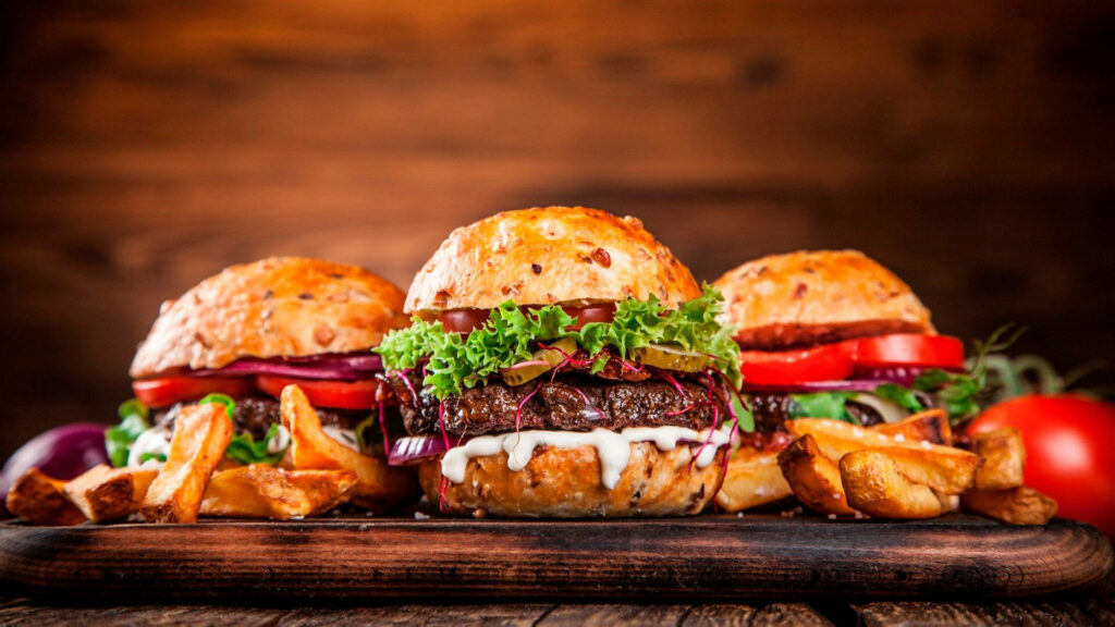 Delicious Premium Cheeseburger Wallpaper with Crispy Fries Background