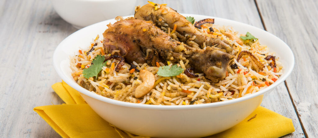 Delicious chicken biryani with basmati rice tender chicken fresh cilantro fried onions cashews Wallpaper