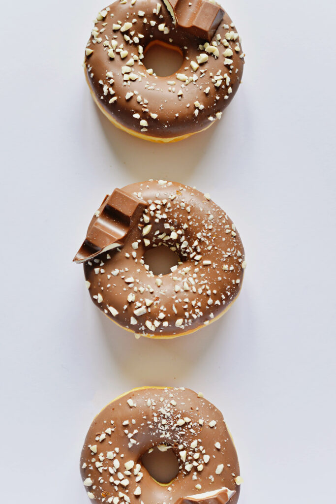 Chocolate-Glazed Donuts Wallpaper: Tasty Treats on White Background
