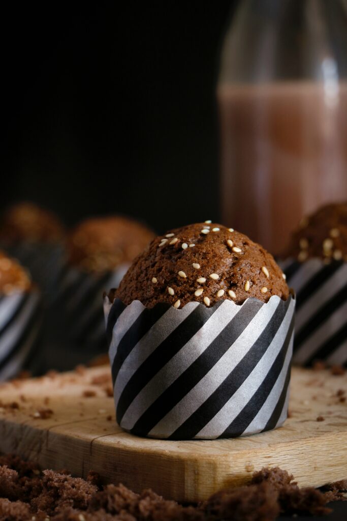 Delicious Chocolate Muffin with Sesame Seeds on Stylish Wooden Surface Wallpaper