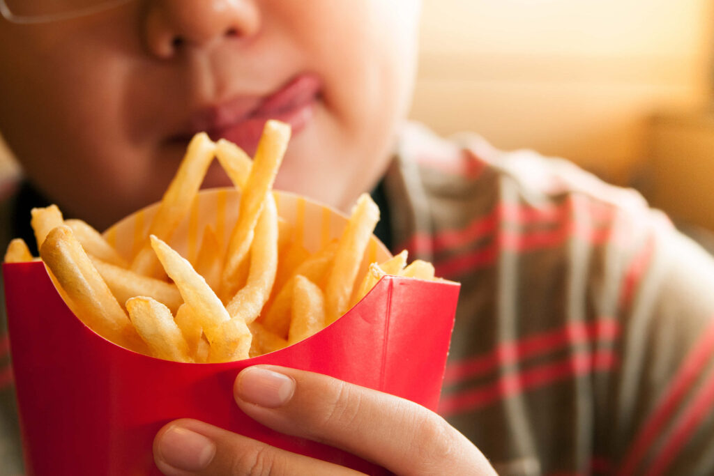Delicious Crispy French Fries in Red Container - Wallpaper Background
