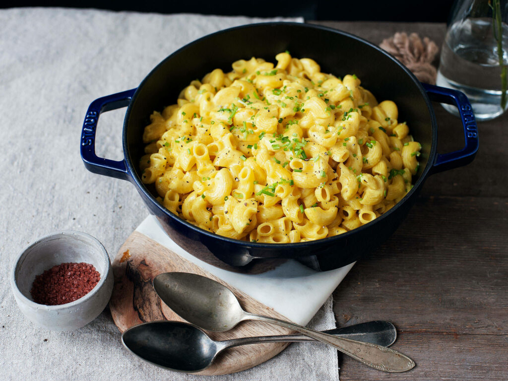 Delicious Crockpot Mac and Cheese in a Blue Pot with Fresh Herbs Wallpaper