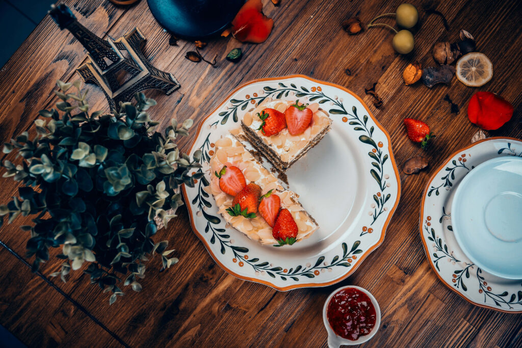 Decadent Delights: Irresistible Cake Slices with Strawberry Toppings, Laid on a Rustic Wooden Table Wallpaper