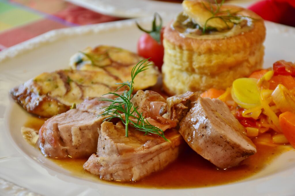 Delicious Pork Dinner Wallpaper with Savory Sauce & Fresh Herbs